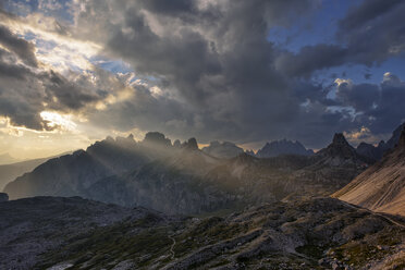 Dreizinnenhütte mit den Bergen Tobliner Knoten, Torre dei Scarperi, Croda dei Rondoi, Cima Piatta Alta und dramatischem Himmel mit Sonnenstrahlen. Parco Naturale Tre Cime, Italien - RUEF02116