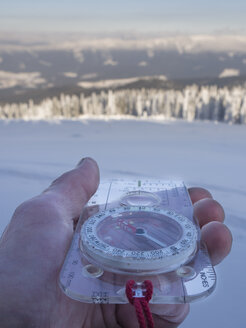 Deutschland, Naturpark Oberer Bayerischer Wald, Kompass in der Hand eines Mannes im Winter - HUSF00014