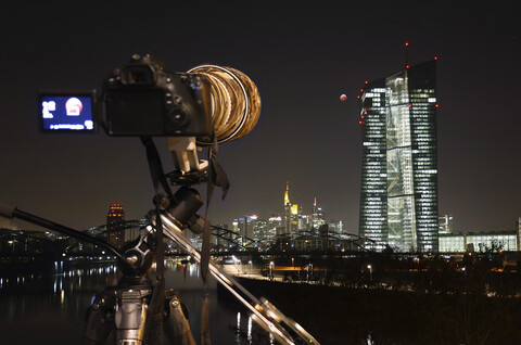 Deutschland, Frankfurt am Main, Blick auf die Europäische Zentralbank bei totaler Mondfinsternis mit Kamera im Bildvordergrund, lizenzfreies Stockfoto