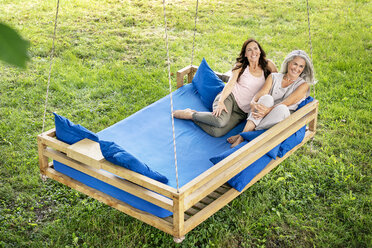 Zwei Frauen entspannen sich auf einem Hängebett im Garten - PESF01266