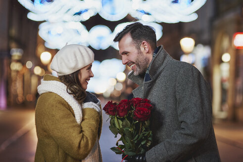 Mann schenkt seiner Freundin einen Strauß roter Rosen zum Valentinstag - ABIF01150