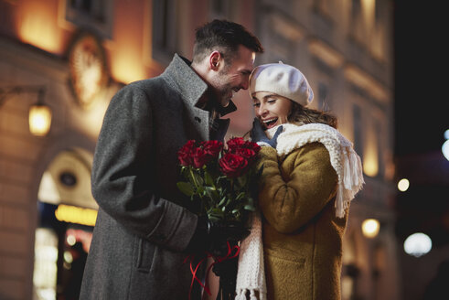 Man giving his amazed girlfriend bunch of red roses on Valentine's Day - ABIF01151