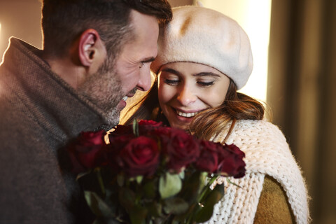 Couple in love with bunch of red roses in winter stock photo