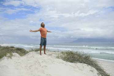 Südafrika, Mann mit erhobenen Armen am Bloubergstrand - ECPF00377