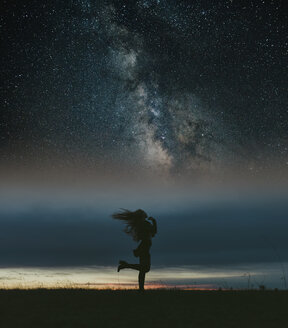 Silhouette of woman dancing on a meadow under starry sky - JPF00349