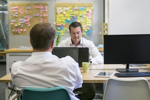 Zwei Geschäftsleute arbeiten am Schreibtisch im Büro - PAF01844