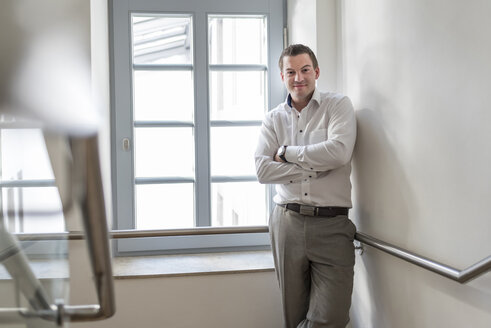 Portrait of confident businessman in staircase - PAF01867