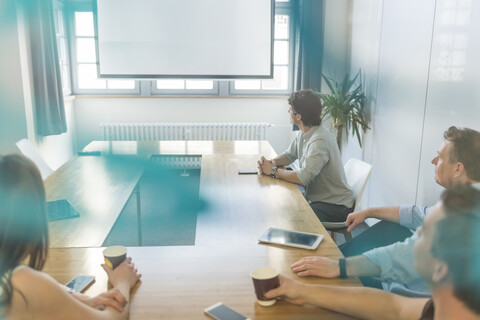Geschäftsleute sitzen am Konferenztisch im Büro, lizenzfreies Stockfoto