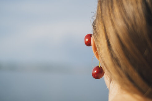 Back view of young woman wearing cherries on ear, close-up - JSCF00138