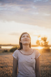 Portrait of young woman relaxing in nature at sunset - JSCF00151