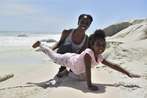 Mutter und Tochter machen eine gymnastische Übung am Strand - ECPF00381