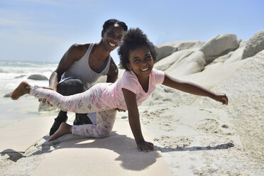 Mutter und Tochter machen eine gymnastische Übung am Strand - ECPF00382