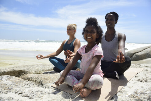Mutter mit Tochter und Freundin bei einer Yogaübung am Strand - ECPF00392
