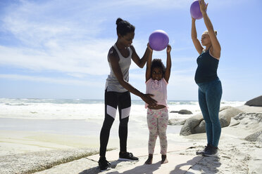 Mutter mit Tochter und Freund beim Training mit einem Ball am Strand - ECPF00399
