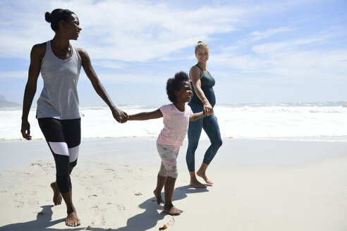 Happy mother with daughter and friend walking on the beach - ECPF00416