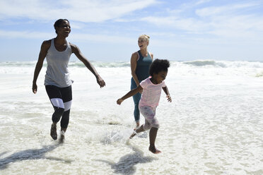 Mutter mit Tochter und Freund haben Spaß in der Brandung am Strand - ECPF00418