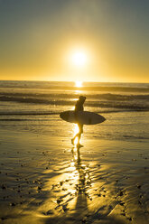 USA, Kalifornien, Del Mar, Surfer am Strand bei Sonnenuntergang - RUNF01132