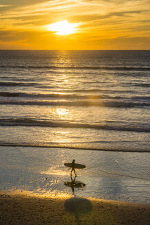 USA, California, Del Mar, female surfer at the beach at sunset - RUNF01136