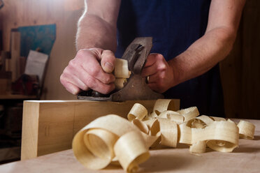 Craftsman using wood plane in workshop - CUF48595