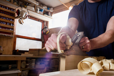 Craftsman using wood plane in workshop - CUF48596