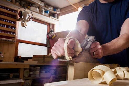 Handwerker mit Holzhobel in der Werkstatt - CUF48596