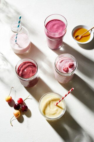 Obst- und Joghurt-Smoothies in Glasflaschen und Gläsern, Blick von oben, lizenzfreies Stockfoto