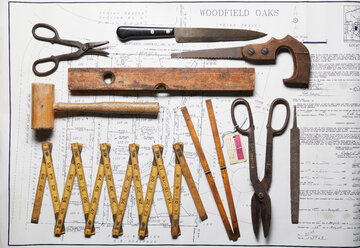 Variety of vintage hand tools on property map, overhead view - CUF48650