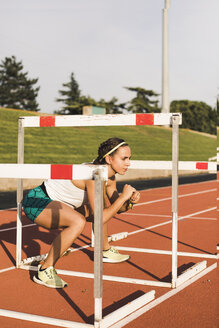 Female athlete doing warm-up exercises on tartan track - ACPF00446