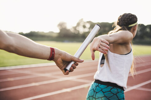 Close-up of a athlete passing the baton to a female athlete - ACPF00449