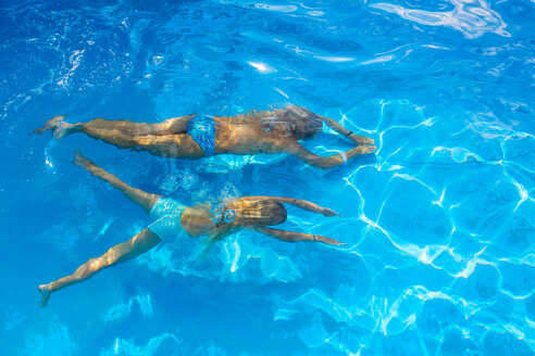Girl and her mother swimming underwater in outdoor swimming pool, high angle view, Vernazza, Liguria, Italy - CUF48668