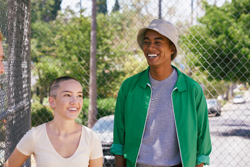 Young man and female friend by park fence, Los Angeles, California, USA - CUF48687