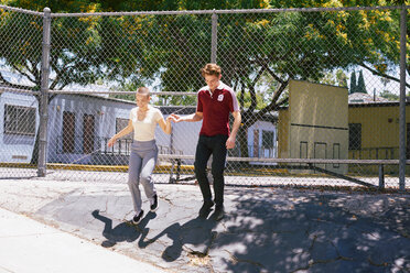 Young man giving female friend a helping hand in park, Los Angeles, California, USA - CUF48690