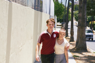 Young man and girlfriend strolling on suburban sidewalk, Los Angeles, California, USA - CUF48691
