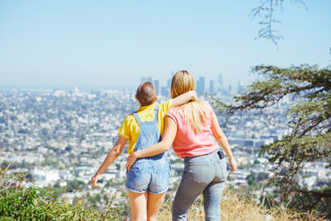 Zwei junge Freundinnen betrachten die Skyline von einer Anhöhe aus, Rückansicht, Los Angeles, Kalifornien, USA - CUF48709