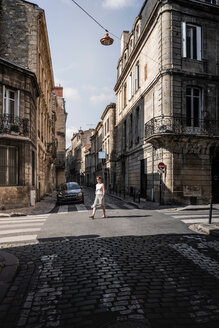 Straßenszene mit Frau beim Überqueren der Straße, Bordeaux, Aquitanien, Frankreich - CUF48790