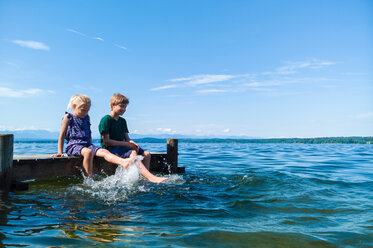 Siblings cooling feet in water, Lake Starnberg, Bavaria, Germany - CUF48821