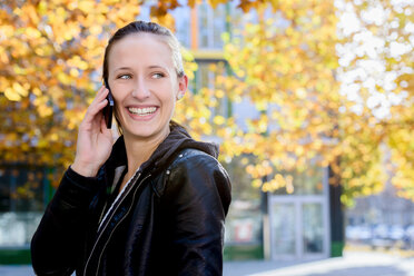 Junge Frau benutzt Smartphone im Park - CUF48825