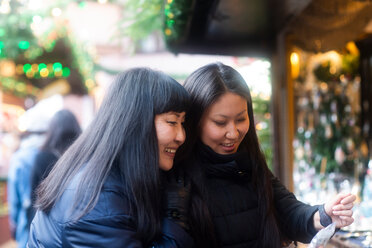 Mother and daughter window shopping at Christmas market, Freiburg, Baden-Wurttemberg, Germany - CUF48831