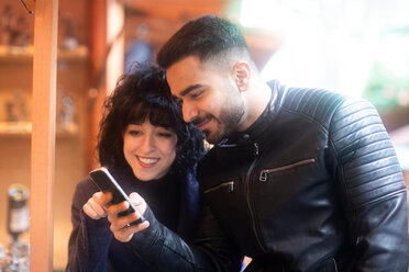 Ehepaar mit Smartphone auf dem Weihnachtsmarkt, Freiburg, Baden-Württemberg, Deutschland - CUF48835