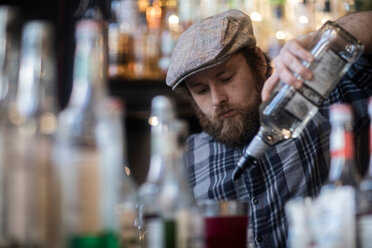 Barkeeper beim Einschenken von Spirituosen in einem traditionellen irischen Gasthaus - CUF48854