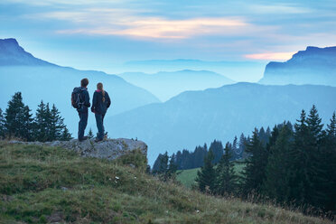 Hikers enjoying view of misty mountains, Manigod, Rhone-Alpes, France - CUF48873