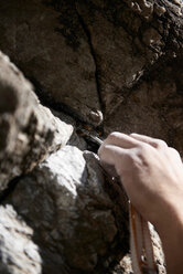 Rock climber anchoring into rock crevice - CUF48897