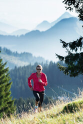 Jogger running up hillside, Manigod, Rhone-Alpes, France - CUF48920