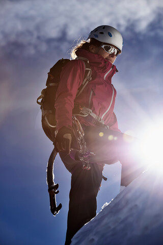 Bergsteiger, der im hellen Sonnenlicht einen Berg besteigt, Chamonix, Rhone-Alpen, Frankreich, lizenzfreies Stockfoto