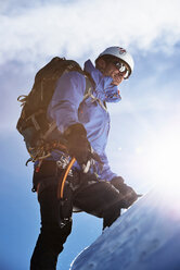 Mountain climber ascending mountain in bright sunlight, Chamonix, Rhone-Alps, France - CUF48931