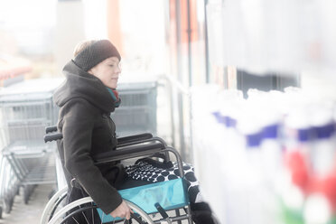 Woman in wheelchair going into supermarket - CUF48951