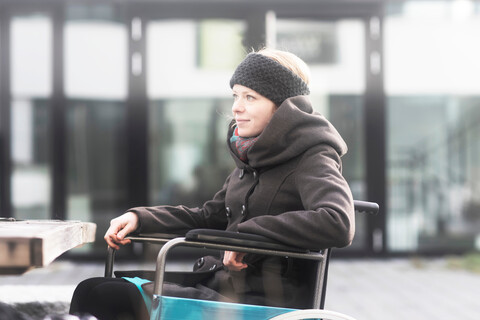 Frau im Rollstuhl auf der Straße, lizenzfreies Stockfoto