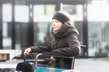 Frau im Rollstuhl auf der Straße - CUF48953