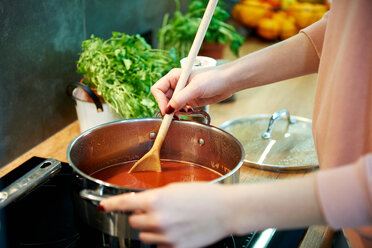 Frau kocht Tomatensuppe in der Küche - CUF49124