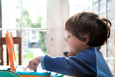 Toddler boy using toy laptop - CUF49148